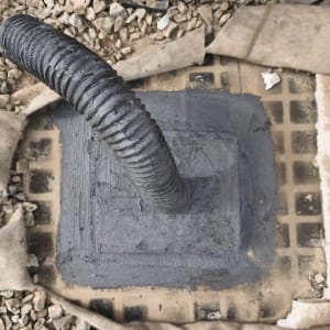 איטום סביב צינור עם חומר אפור על רצפה