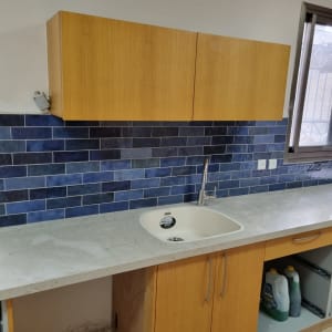 מטבח בשיפוץ עם ארונות עץ וכיור מותקן