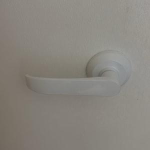 ידית דלת לבנה על רקע קיר