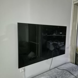 טלוויזיה מותקנת על קיר עם כבל חשמל מחובר