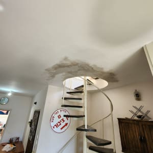 כתם רטיבות בתקרה מעל מדרגות ספירליות