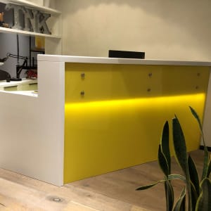 דלפק עץ צבוע בצהוב ולבן עם מדף עליון