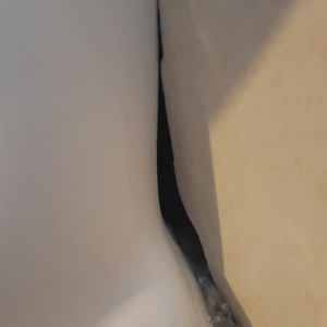 סדק בין קיר לאסלה עם סימני רטיבות