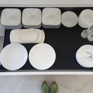 צלחות מסודרות במגירה עם כוסות זכוכית