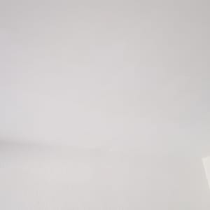 תקרה וקיר צבועים בלבן עם חוט חשמל שחור