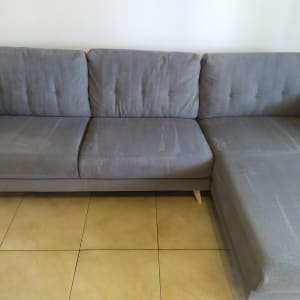 ספה אפורה עם סימני ניקוי על הריפוד