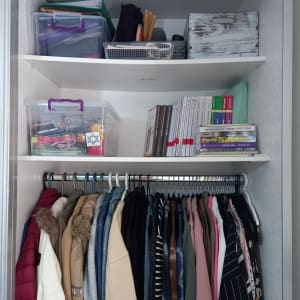 ארון בגדים עם קופסאות פלסטיק, ספרים ובגדים תלויים