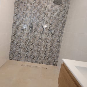 מקלחת עם אריחים מעוצבים וברזים חדשים