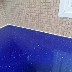 משטח שיש כחול מבריק עם קיר אריחים בהיר