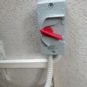 מתג חשמלי עם ידית אדומה על קיר