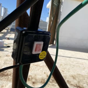 קופסת חשמל עם כפתור אדום וכבלים ירוקים ושחורים