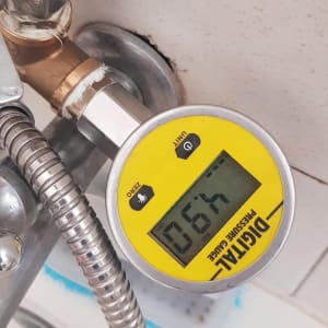 מד לחץ דיגיטלי מחובר לצינור מתכת