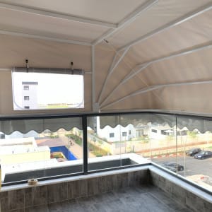 סוכך בד לבן עם מסגרת מתכת על מרפסת