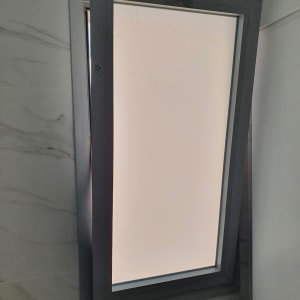 חלון אלומיניום פתוח עם מסגרת אפורה