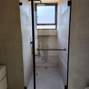 דלת זכוכית למקלחת עם מסגרת שחורה