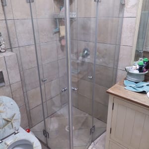 מקלחון זכוכית עם מדף מוצרים וסבון תלוי