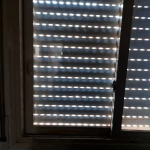 חלון זכוכית עם תריסים סגורים למחצה