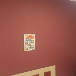 קיר צבוע באדום עם תמונה קטנה תלויה