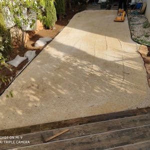 שביל חצץ עם מכבש, שקי אדמה וצינור השקיה