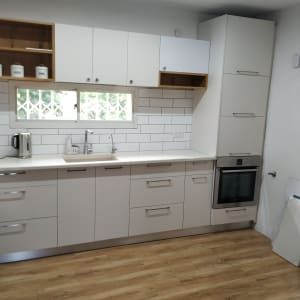 מטבח מודרני עם ארונות לבנים, תנור וכיור