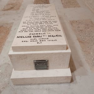 מצבה עם כיתוב בעברית על רצפת אבן