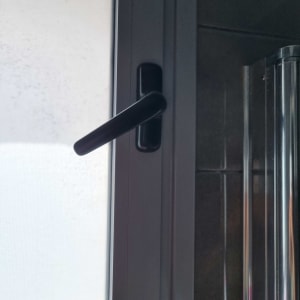 ידית תריס שחורה על חלון זכוכית