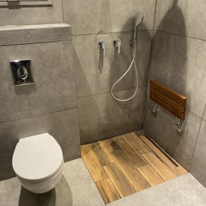 שירותים עם מקלחון, אריחים אפורים ורצפת עץ