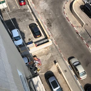 אדם על חבל צובע קיר חיצוני של בניין