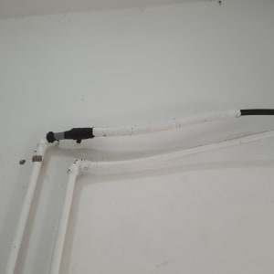 צינורות מים עם בידוד על קיר לבן