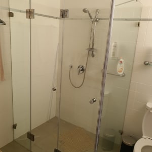 מקלחון זכוכית עם ראש מקלחת ומדף סבון