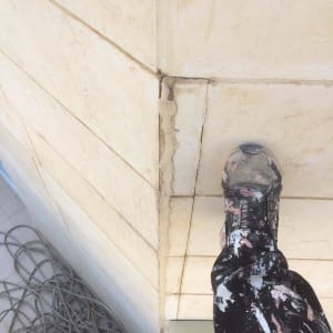 אדם עומד על קיר עם סדק ותיקון איטום