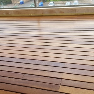wooden deck with horizontal planks and glass railing
