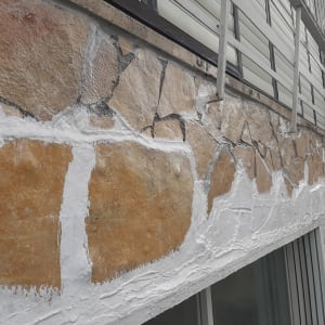 קיר אבן עם תיקוני טיח לבנים