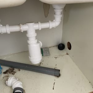 צנרת פלסטיק לבנה מתחת לכיור עם חיבורים