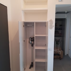 ארון לבן עם מדפים ודלתות פתוחות