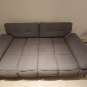 ספה אפורה עם ריפוד מרופד על רצפה בהירה