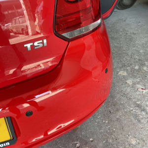 חלק אחורי של רכב אדום עם פגוש ופנס