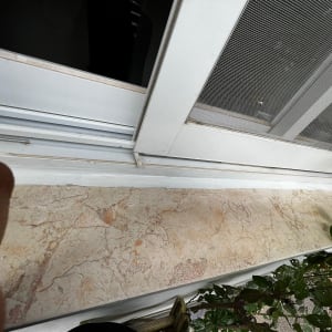 חלון עם מסגרת לבנה ואטימה לאורך המסילה