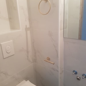 חדר אמבטיה עם אריחים חדשים, מתקן נייר טואלט מוזהב