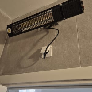 תנור חימום חשמלי מותקן על קיר עם חיבור לחשמל