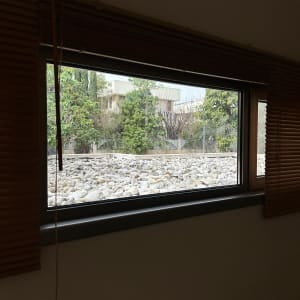 חלון זכוכית עם נוף של עצים ואבנים