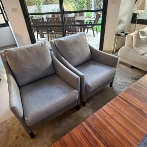 זוג כורסאות מרופדות בבד אפור בעל מרקם בסלון מודרני