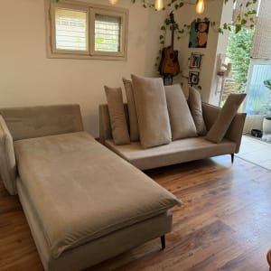 ספות בסלון עם כריות, רצפת עץ וצמחים