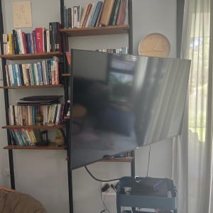 טלוויזיה תלויה על קיר עם כבלים חשמליים