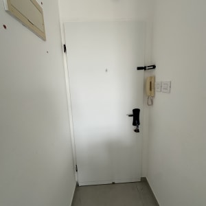 דלת לבנה עם ידית שחורה ומנעול