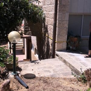 צינור שחור מונח על אדמה ליד מדרגות אבן