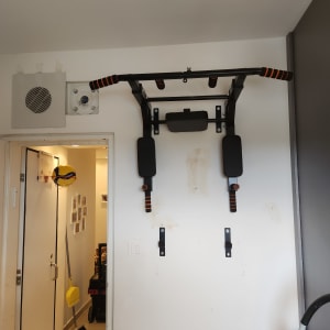 מתקן מתח לקיר עם ידיות כתומות ושחורות