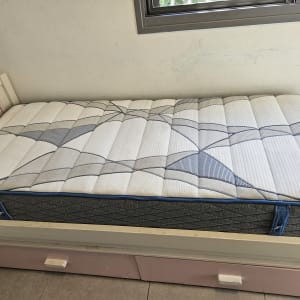 מזרן על מיטה עם כיסוי בד מעוצב