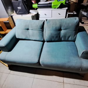 ספה כחולה בחדר עם כלים שונים סביב