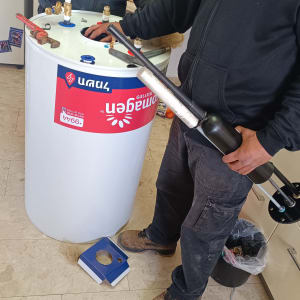 שני אנשים עובדים על דוד שמש עם כלים